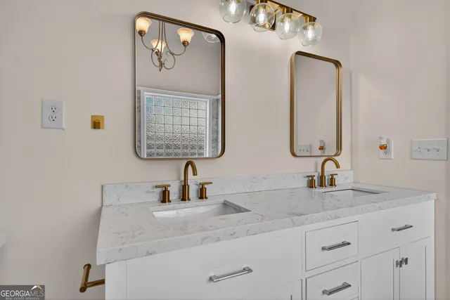 a bathroom with double vanity sinks and a mirror