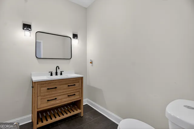 a bathroom with a toilet a sink and mirror