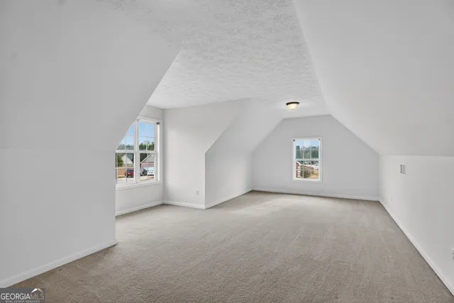 an empty room with windows and cabinet