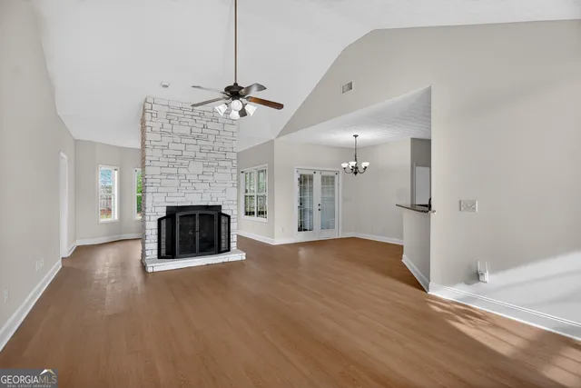 a view of empty room with wooden floor and fireplace