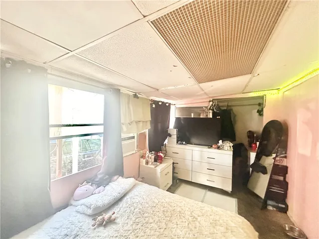 a bed sitting in a bedroom next to a window with kitchen