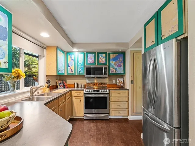 a kitchen with stainless steel appliances a stove a sink and a refrigerator