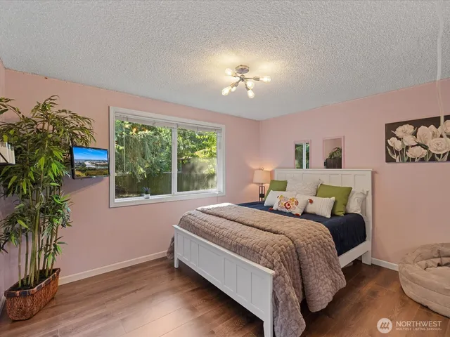 a bedroom with a bed and a potted plant