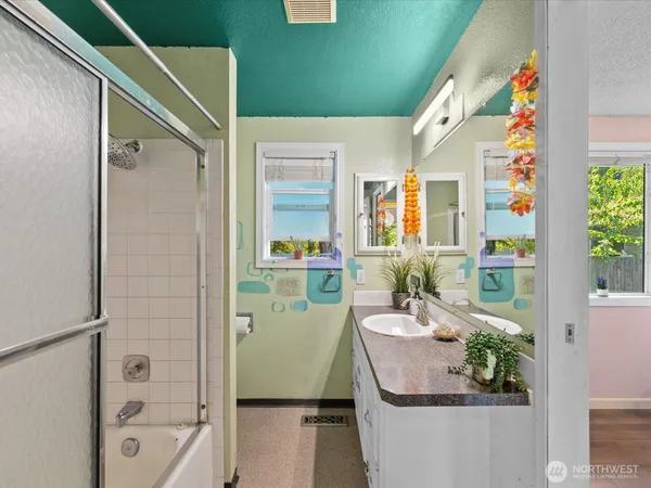 a bathroom with a sink and mirror with bathtub