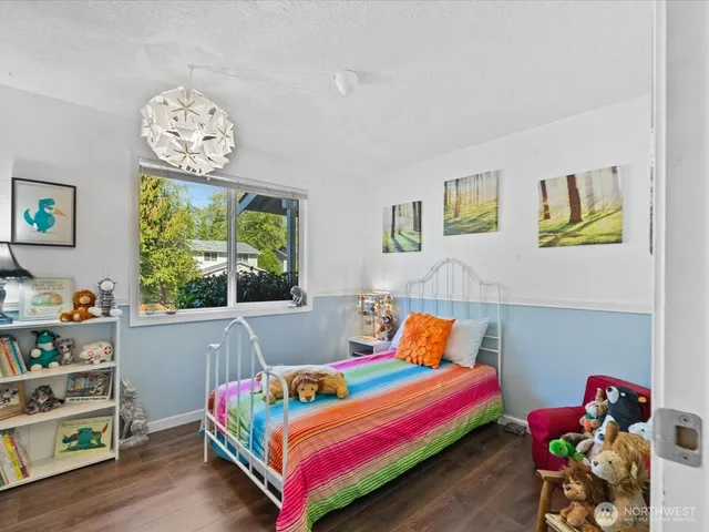 a bedroom with a bed and a wooden floor