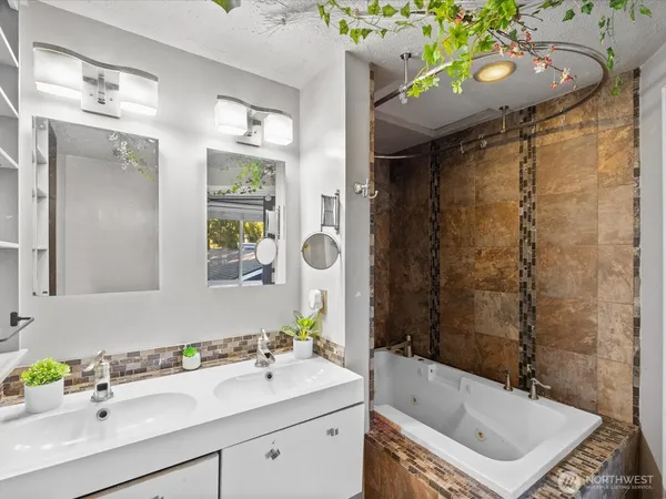 a bathroom with a sink mirror vanity and bathtub