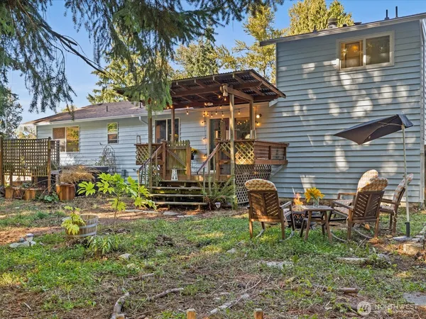 a backyard of a house with barbeque oven table and chairs