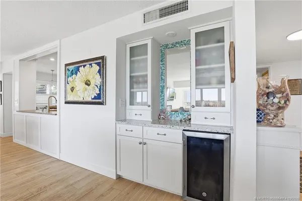 a dining room with wooden floor a chandelier a wooden table and chairs