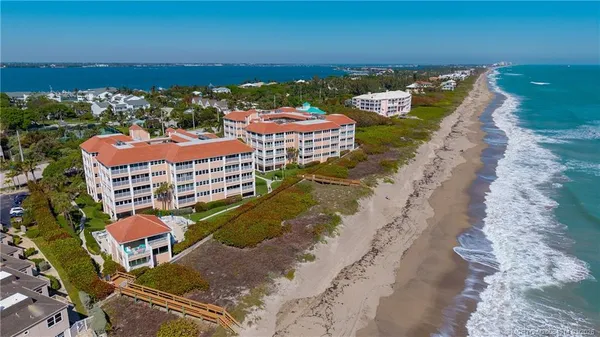a front view of multi story residential apartment building with yard and green space