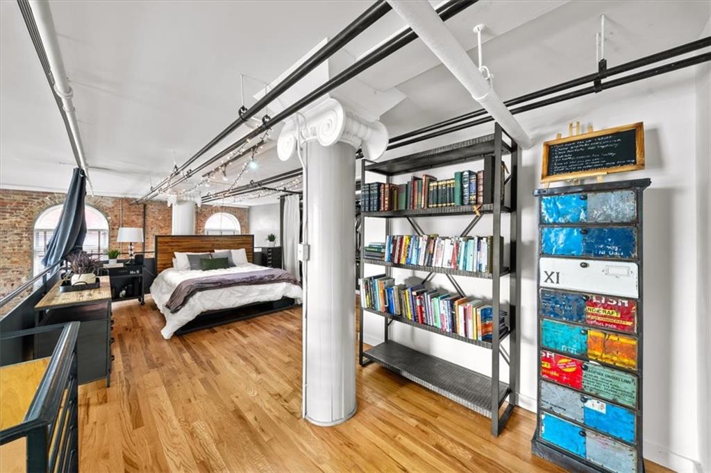 330 Peters Street Southwest, Unit 105 Atlanta, GA 30313 - Photo 14 of 27 a bedroom with furniture and a book shelf