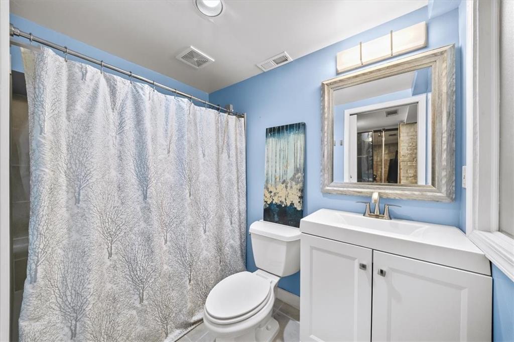 330 Peters Street Southwest, Unit 105 Atlanta, GA 30313 - Photo 19 of 27 a bathroom with a toilet a sink and a mirror