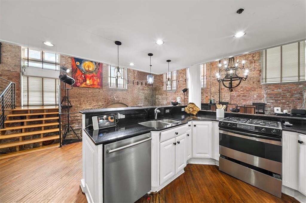 330 Peters Street Southwest, Unit 105 Atlanta, GA 30313 - Photo 6 of 27 a kitchen with stainless steel appliances granite countertop a stove and a sink