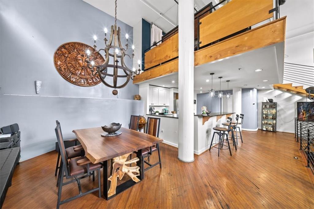330 Peters Street Southwest, Unit 105 Atlanta, GA 30313 - Photo 8 of 27 a dining room with wooden floor a chandelier a wooden table and chairs
