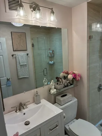 a bathroom with a sink mirror and toilet