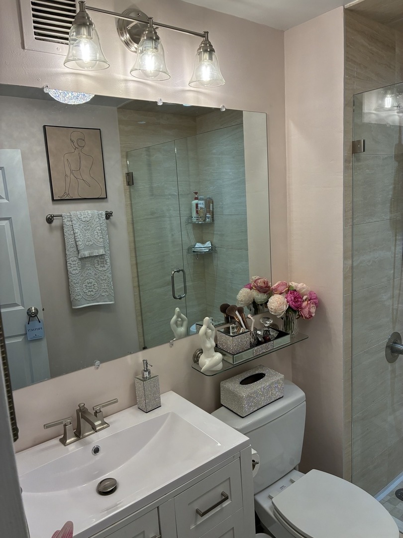 110 East Delaware Place, Unit 2003 Chicago, IL 60611 - Photo 13 of 13 a bathroom with a sink mirror and toilet