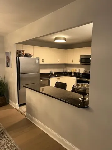 a kitchen with stainless steel appliances granite countertop a refrigerator and a stove