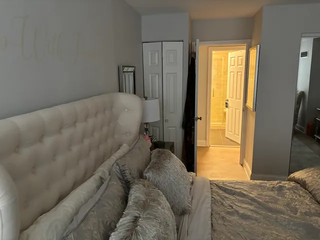 a bed sitting in a bedroom next to a window and a flat tv screen