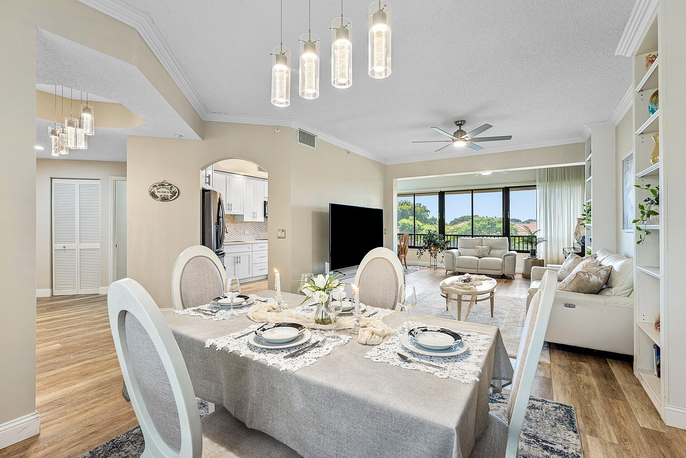 7546 La Paz Boulevard, Unit 404 Boca Raton, FL 33433 - Photo 13 of 47 a dining room with wooden floor a chandelier a glass table and chairs