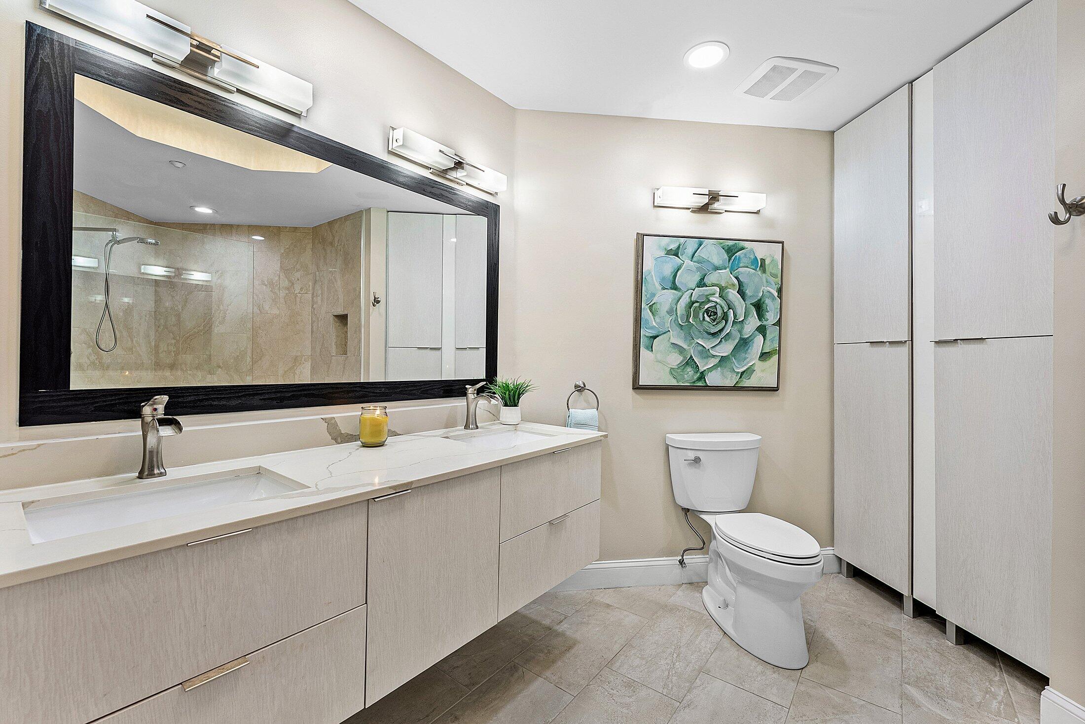 7546 La Paz Boulevard, Unit 404 Boca Raton, FL 33433 - Photo 20 of 47 a bathroom with a toilet sink and mirror