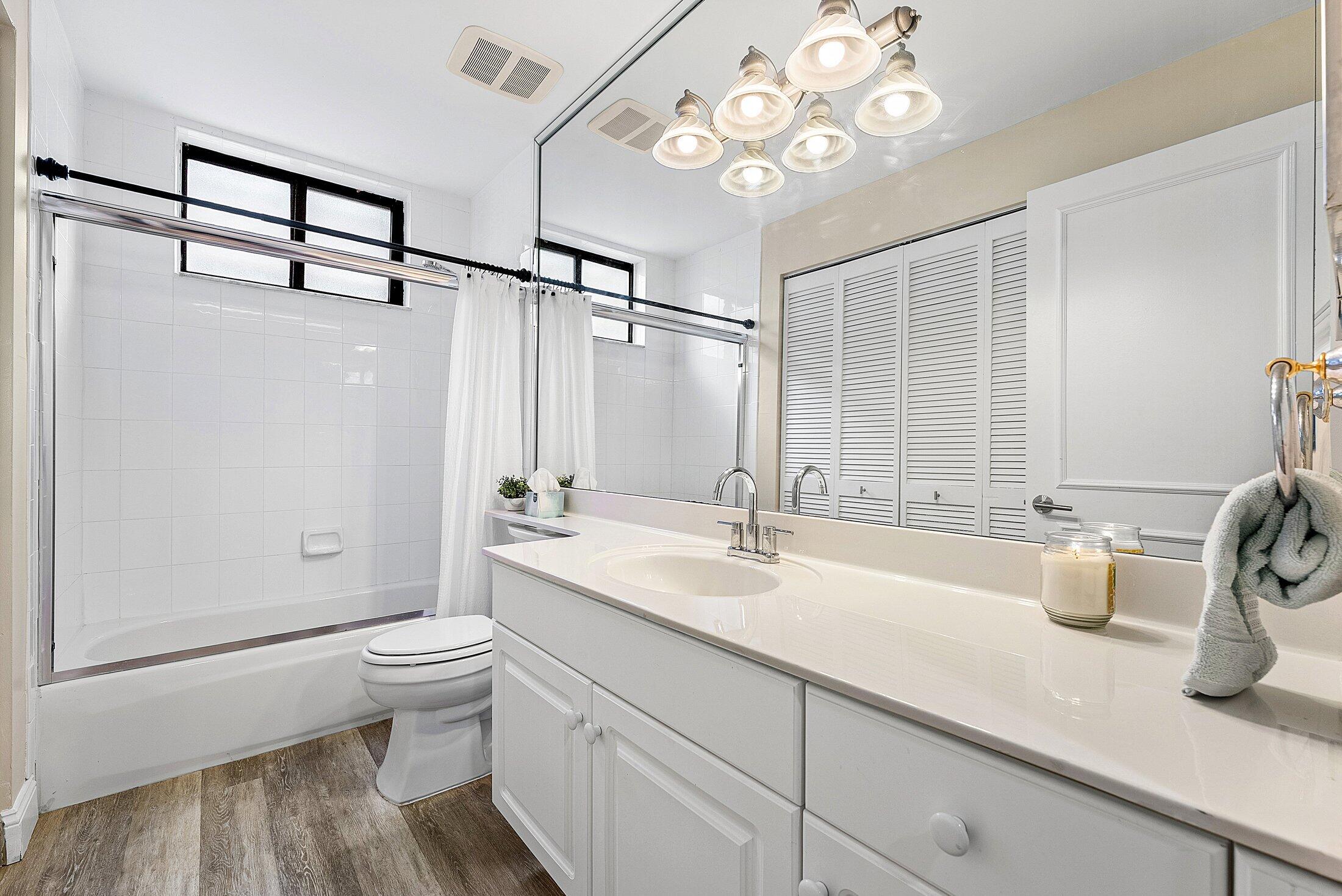 7546 La Paz Boulevard, Unit 404 Boca Raton, FL 33433 - Photo 26 of 47 a bathroom with a double vanity sink toilet mirror and bathtub