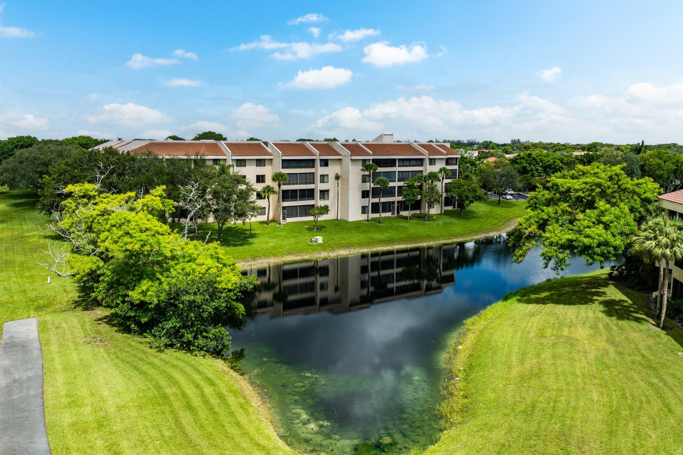 7546 La Paz Boulevard, Unit 404 Boca Raton, FL 33433 - Photo 33 of 47 a view of a swimming pool with a yard and plants