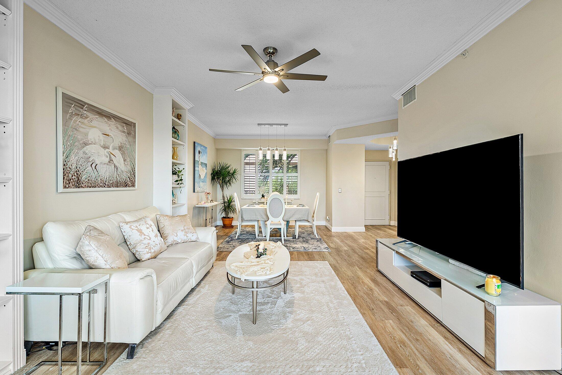 7546 La Paz Boulevard, Unit 404 Boca Raton, FL 33433 - Photo 6 of 47 a living room with furniture and a flat screen tv