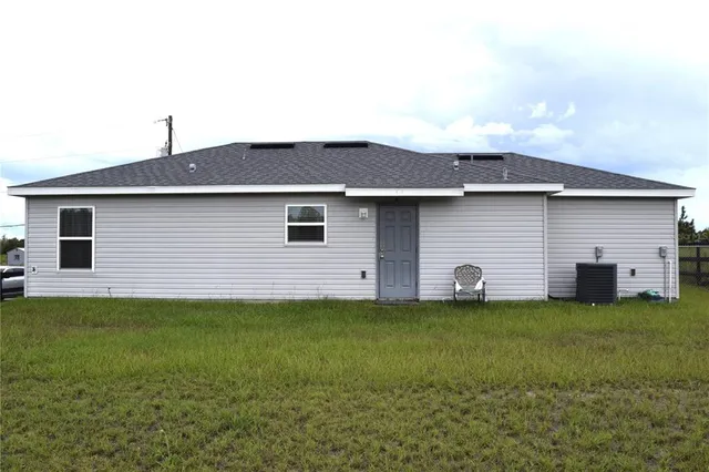 a backyard of a house with table and chairs