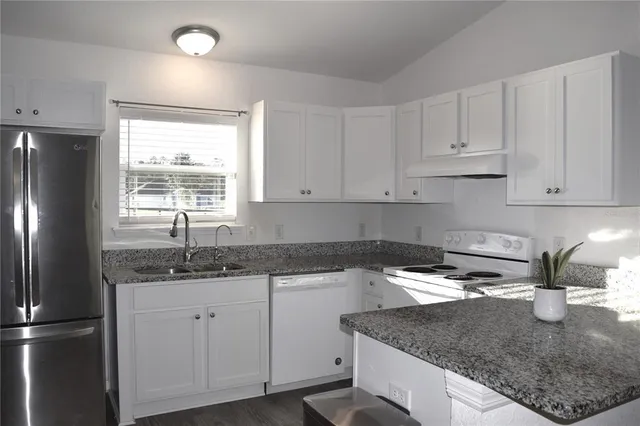 a kitchen with a sink a refrigerator and window