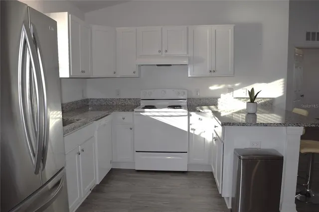 a kitchen with a white cabinets and a refrigerator