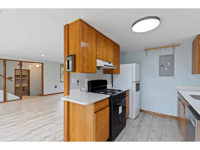 a kitchen with stainless steel appliances granite countertop a stove a sink and a refrigerator