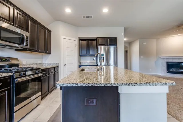 a kitchen with stainless steel appliances granite countertop a refrigerator and a stove top oven
