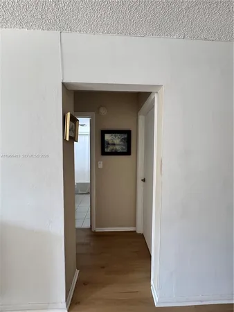 a view of a hallway with wooden floor