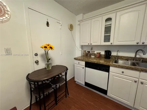 a kitchen with stainless steel appliances granite countertop a sink a stove and wooden floor