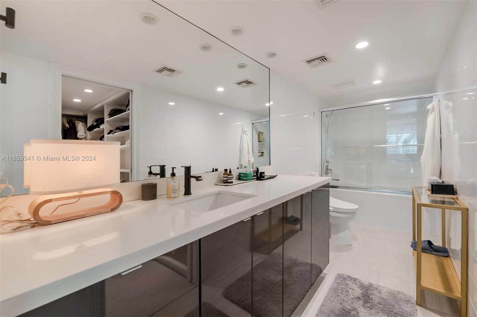 3266 Virginia Street, Unit B3 Miami, FL 33133 - Photo 13 of 24 a bathroom with a double vanity sink a mirror and shower