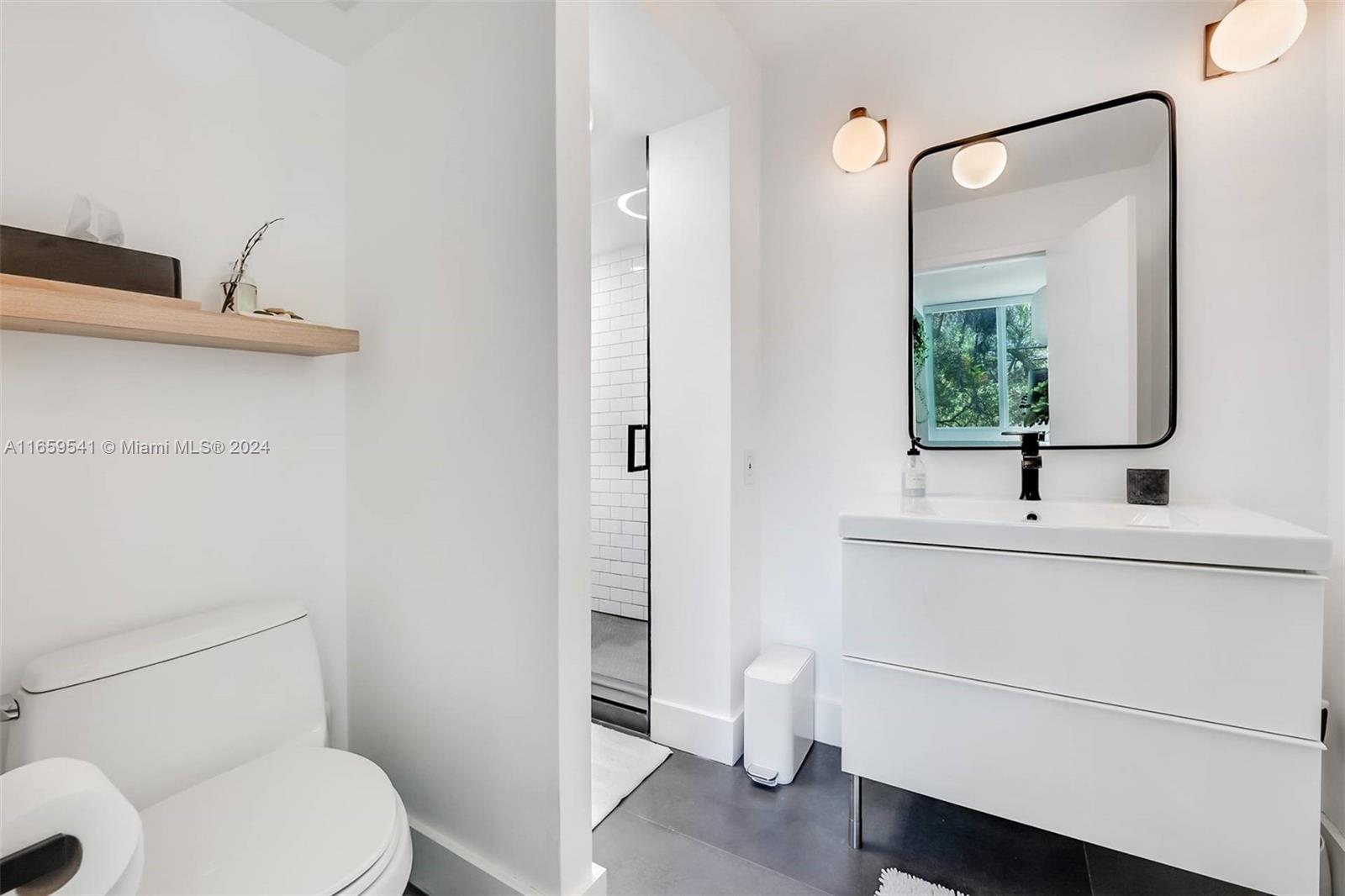 3266 Virginia Street, Unit B3 Miami, FL 33133 - Photo 15 of 24 a bathroom with a sink a toilet and mirror