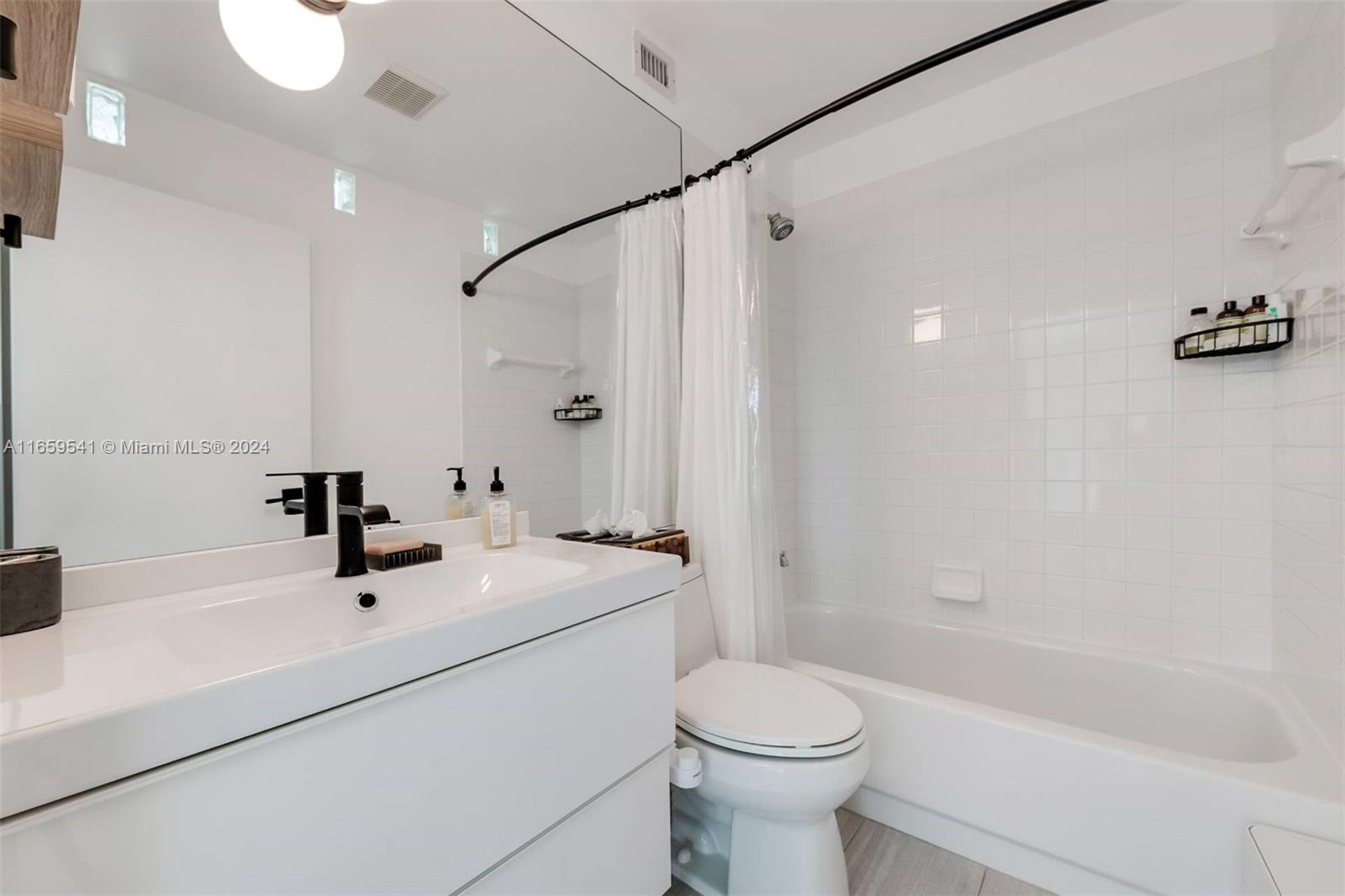 3266 Virginia Street, Unit B3 Miami, FL 33133 - Photo 16 of 24 a bathroom with a sink a toilet and shower