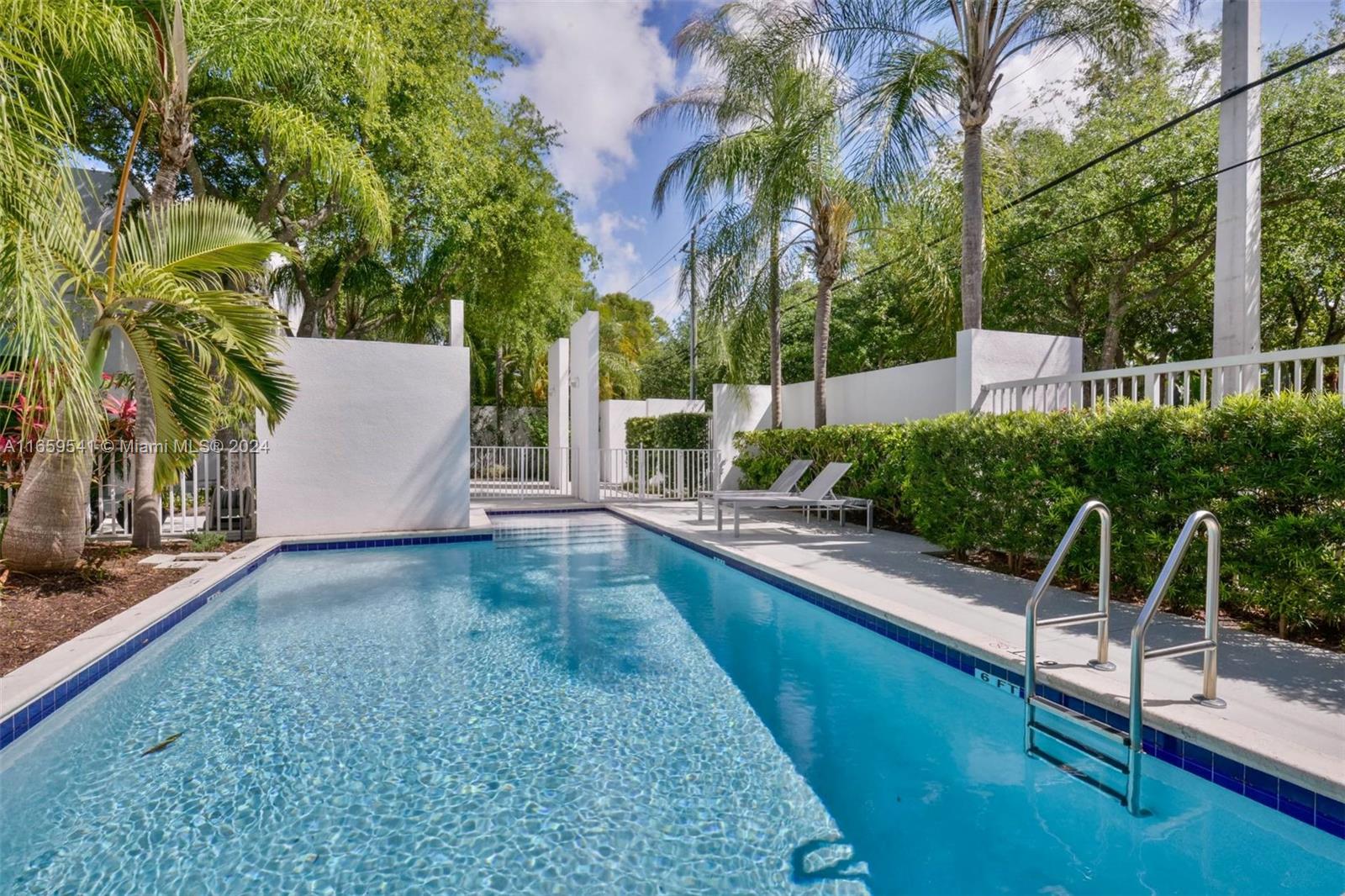 3266 Virginia Street, Unit B3 Miami, FL 33133 - Photo 19 of 24 a view of a backyard with lawn chairs potted plants and palm tree