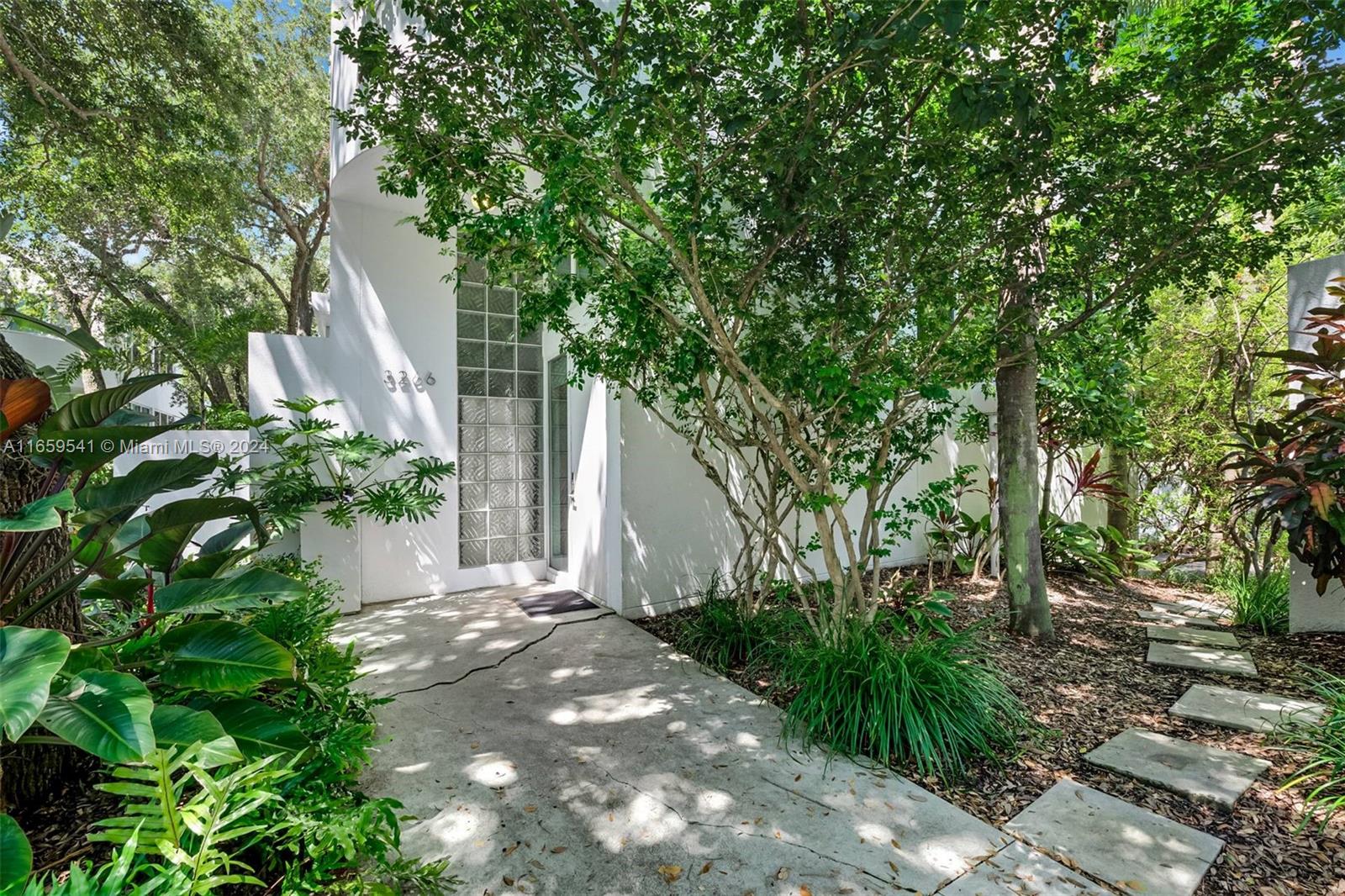 3266 Virginia Street, Unit B3 Miami, FL 33133 - Photo 2 of 24 a view of backyard with plants and trees