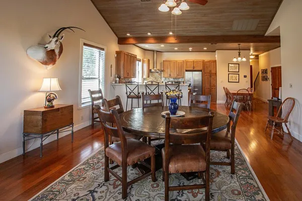 a living room with furniture a ceiling fan and a large window
