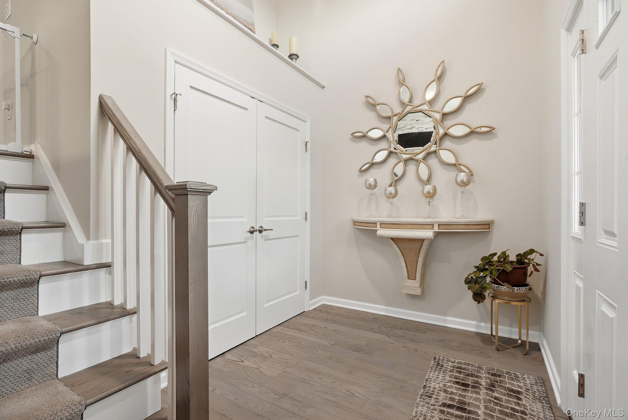 8 Muscoot River Road Granite Springs, NY 10527 - Photo 4 of 40 Entryway featuring wood-finish flooring, a staircase with carpeted treads and wood handrail, double panel doors, and a decorative wall shelf