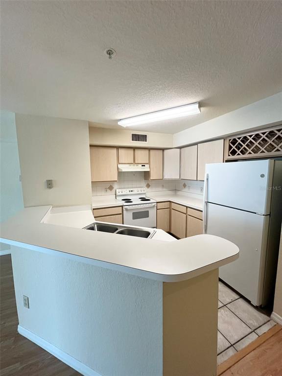 824 Camargo Way, Unit 211 Altamonte Springs, FL 32714 - Photo 5 of 24 a kitchen with a sink a stove a refrigerator and white cabinets