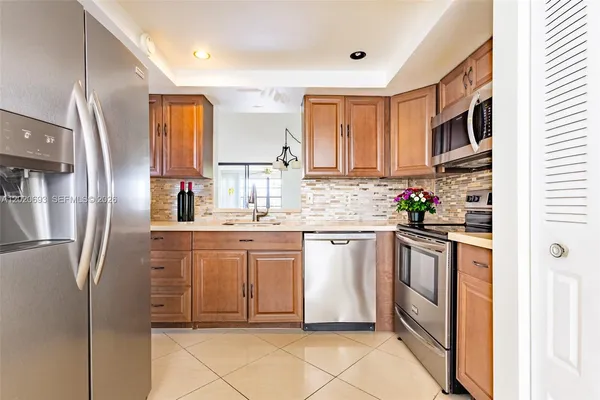 a kitchen with stainless steel appliances granite countertop a refrigerator sink and stove