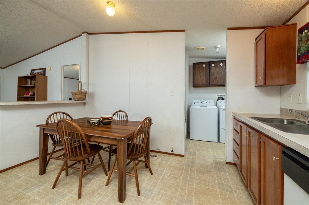 207 Lazy B Lane Springtown, TX 76082 - Photo 20 of 39 Dining area with separate washer and dryer, light tile patterned floors, sink, a textured ceiling, and lofted ceiling