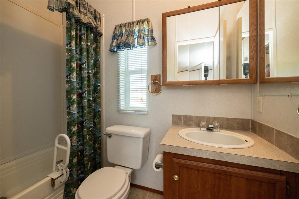 207 Lazy B Lane Springtown, TX 76082 - Photo 28 of 39 Full bathroom featuring shower / tub combo with curtain, toilet, and vanity