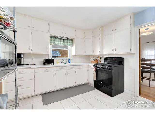a kitchen with stainless steel appliances a stove a sink and white cabinets