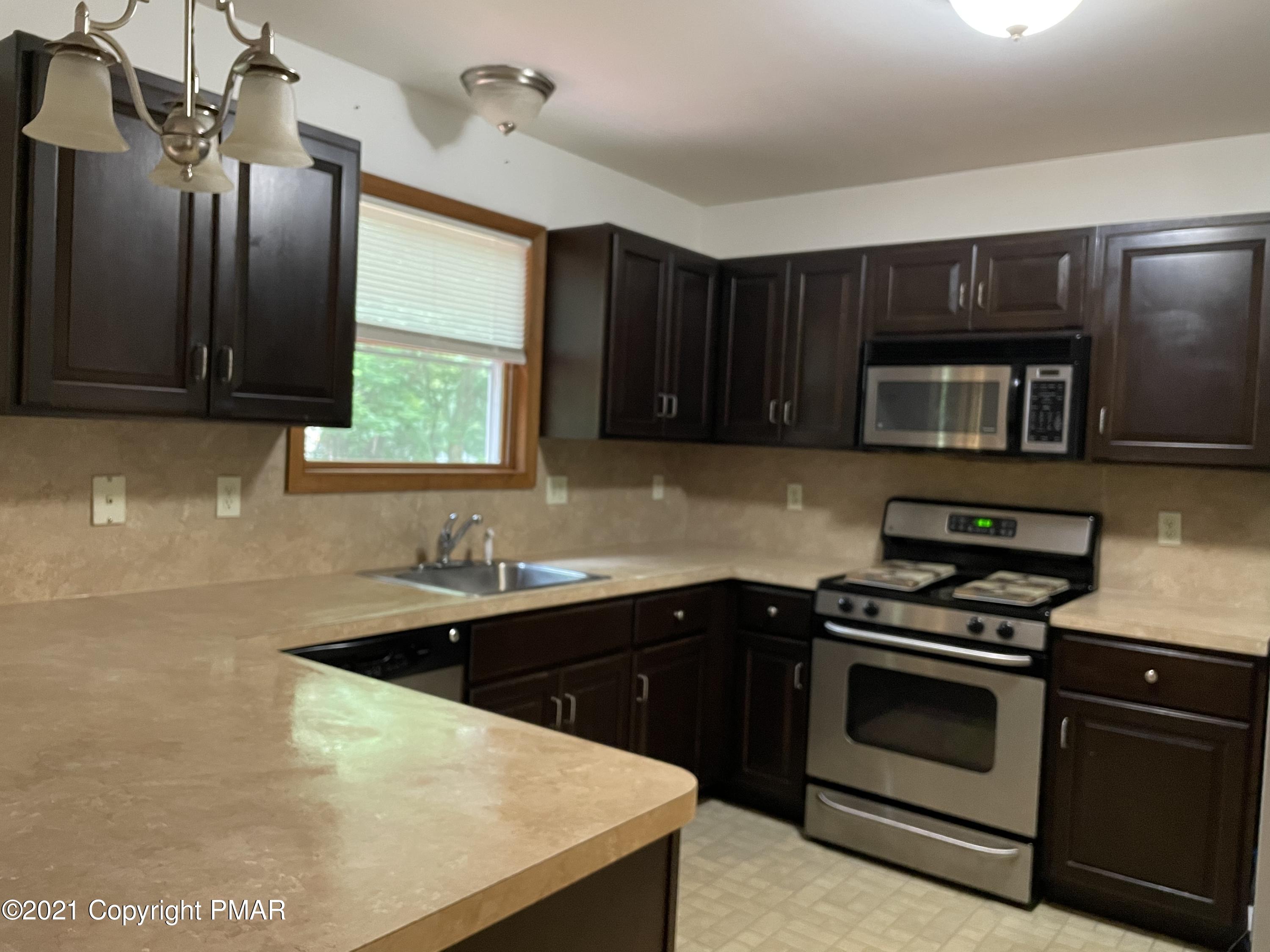 3294 Red Run Road Pocono Summit, PA 18346 - Photo 4 of 36 a kitchen with stainless steel appliances a stove a sink and a microwave