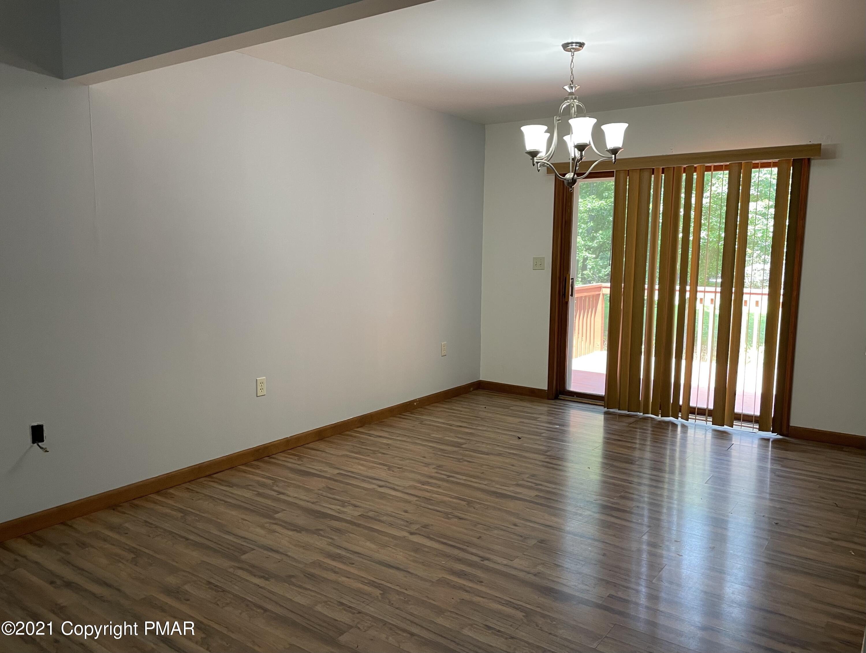 3294 Red Run Road Pocono Summit, PA 18346 - Photo 7 of 36 a view of an empty room with wooden floor and a window