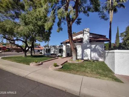 a view of a house with garden and a tree