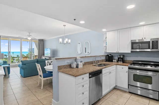 a kitchen with stainless steel appliances kitchen island granite countertop a refrigerator and a sink