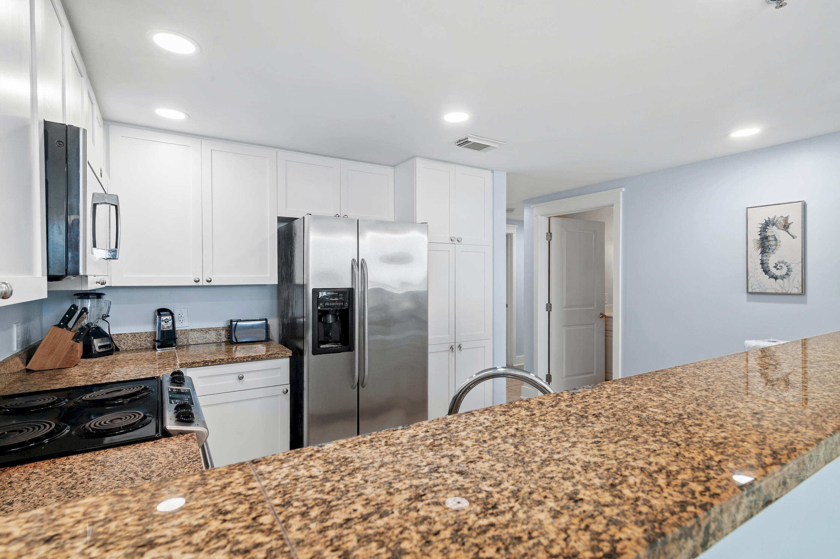 1110 Santa Rosa Boulevard, Unit C500 Fort Walton Beach, FL 32548 - Photo 16 of 59 a kitchen with stainless steel appliances kitchen island granite countertop a refrigerator and a sink